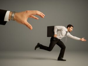 A man running away from a hand symbolizing not letting your business run you